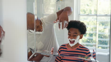 Father-And-Son-At-Home-Having-Fun-Playing-With-Shaving-Foam-In-Bathroom-Making-A-Mess-Together