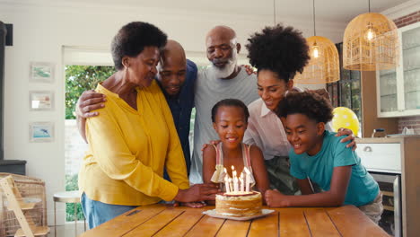 Mehrgenerationenfamilie-Feiert-Zu-Hause-Den-Geburtstag-Ihrer-Enkelin-Mit-Kuchen-Und-Kerzen