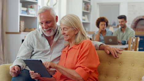 Seniorenpaar-Im-Ruhestand-Zu-Hause-Mit-Digitalem-Tablet,-Das-Mit-Kreditkarte-Kauft-Oder-Bucht