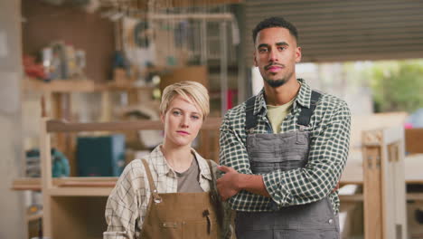 Portrait-Of-Serious-Male-And-Female-Apprentices-Working-As-Carpenters-In-Furniture-Workshop