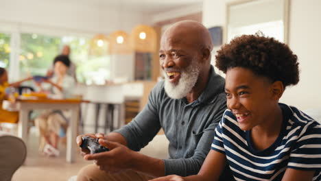 Großvater-Und-Enkel-Sitzen-Zu-Hause-Auf-Dem-Sofa-Und-Spielen-Gemeinsam-Videospiele