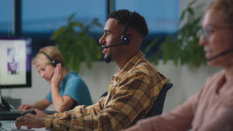 Business-Team-Wearing-Headsets-Working-Late-At-Customer-Support-Centre