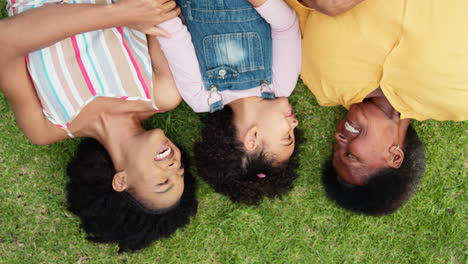 Overhead-Shot-Of-Smiling-Multi-Generation-Female-Family-Lying-On-Grass-In-Garden-Together