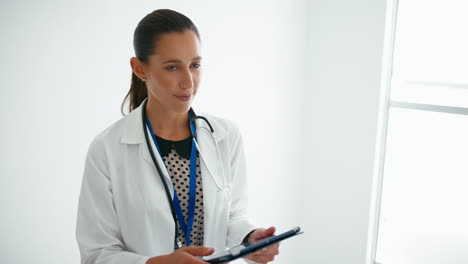 Doctora-Con-Tableta-Digital-Comprobando-Notas-De-Pacientes-En-Las-Escaleras-Del-Hospital