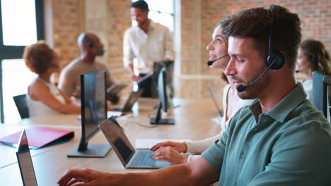 Portrait-Of-Businessman-In-Multi-Cultural-Business-Team-Wearing-Headset-In-Customer-Support-Centre