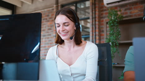 Businesswoman-In-Business-Team-Wearing-Headset-In-Customer-Support-Centre