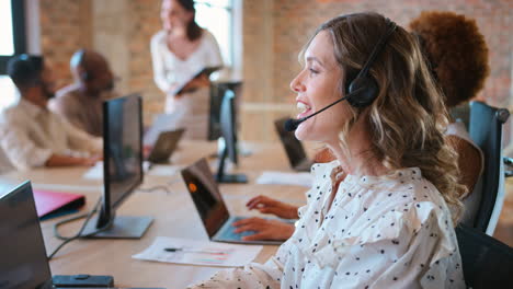 Businesswoman-In-Multi-Cultural-Business-Team-Wearing-Headset-In-Customer-Support-Centre