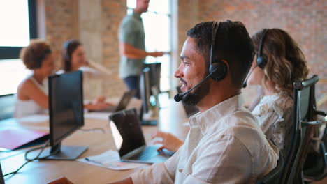 Portrait-Of-Businessman-In-Multi-Cultural-Business-Team-Wearing-Headset-In-Customer-Support-Centre