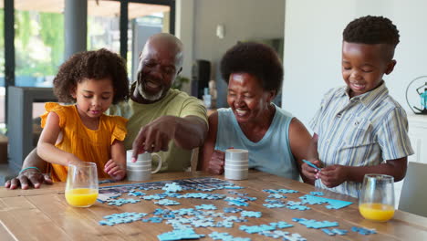 Familienfoto-Mit-Großeltern-Und-Enkelkindern,-Die-Zu-Hause-Auf-Dem-Tisch-Puzzles-Machen