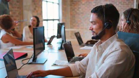 Multi-Cultural-Business-Team-Wearing-Headsets-Working-In-Customer-Support-Centre