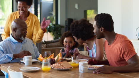 Familienaufnahme-Mit-Großeltern,-Eltern-Und-Enkelin-Beim-Frühstück-Am-Heimischen-Tisch