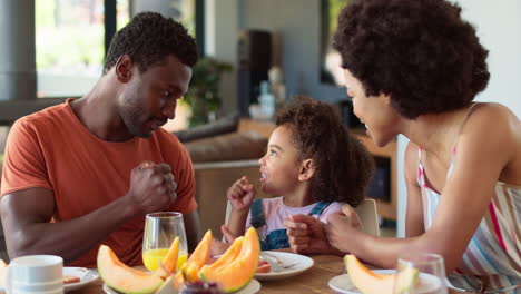 Familienaufnahme-Mit-Eltern-Und-Tochter-Zu-Hause-Beim-Spielen-Am-Tisch-Vor-Dem-Frühstück