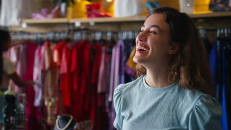 Portrait-Of-Smiling-Female-Owner-Or-Worker-In-Fashion-Clothing-Store