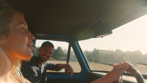 Gruppe-Lächelnder-Freunde-Auf-Roadtrip,-Die-Im-Fahrerhaus-Eines-Pick-up-Trucks-Fahren