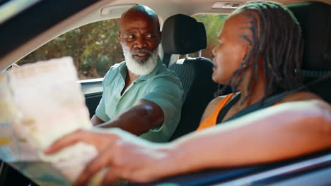 Senior-Couple-In-Car-With-Map-Arguing-About-Directions-On-Day-Trip-Out
