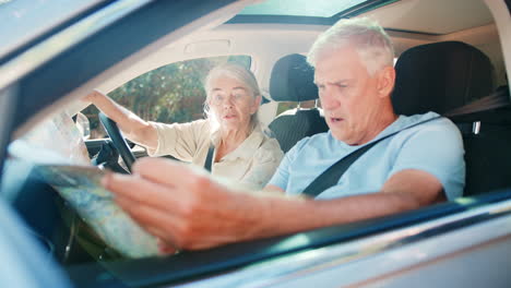 Senior-Couple-In-Car-With-Map-Arguing-About-Directions-On-Day-Trip-Out