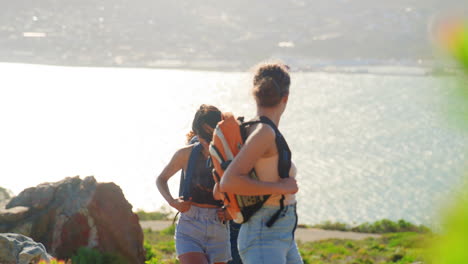Group-Of-Female-Friends-With-Backpacks-On-Vacation-On-Hike-Through-Countryside-On-Coastal-Path