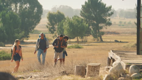 Group-Of-Friends-With-Backpacks-Hiking-In-Countryside-Together