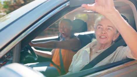 Passenger-Taking-Photo-On-Mobile-Phone-As-Two-Senior-Female-Friends-Enjoy-Day-Trip-Out-In-Car