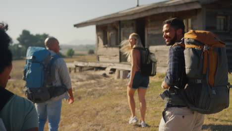 Rear-View-Of-Group-Of-Friends-With-Backpacks-Hiking-In-Countryside-Together