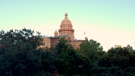 Downtown-Austin,-Texas-State-Capital-Building,-Aerial-Drone-Shot-Flying-Flying-Up-Through-the-Courtyard-Trees-on-the-West-Wing-of-the-Building