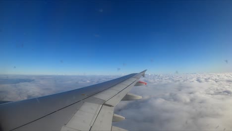 Eine-Malerische-Aussicht-Auf-Wolken-Aus-Dem-Fenster-Eines-Fliegenden-Flugzeugs