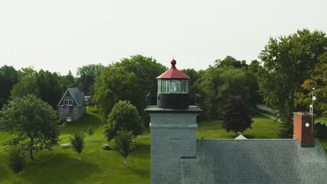 Drohnenaufnahme-Des-Großen-Leuchtturmmuseums,-Das-Auf-Die-Große-Linse-Am-Urlaubsort-Sodus-Point-In-New-York-An-Der-Landspitze-Am-Ufer-Des-Ontariosees-Geschoben-Wird