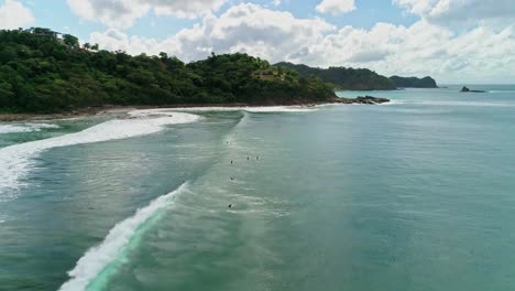 Aerial-forward-over-surfers-in-the-ocean-on-the-coast-of-San-Juan-del-Sur