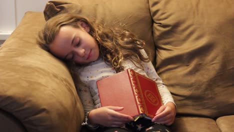 LITTLE-GIRL-ASLEEP-ON-COUCH-AFTER-READING-BOOK