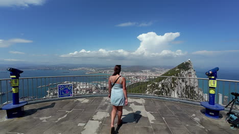 Lady-approaching-rails-to-see-panoramic-view-captured-from-the-cable-car-top-station-in-Gibraltar,-revealing-the-breathtaking-landscape