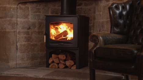 Lit-wood-burning-stove-next-to-leather-armchair