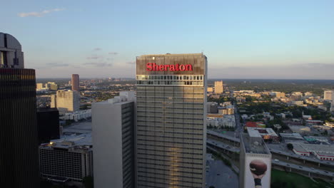 Aerial-view-approaching-the-Sheraton-hotel,-sunny-evening-in-Dallas,-USA