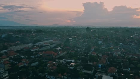Panoramic-panning-aerial-view-of-misty-morning-in-Ubud-center---Bali-at-sunrise-with-mount-agung-Volcano-in-Background
