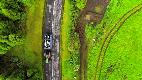 Aerial-image-of-a-tractor-transporting-cows-in-an-agricultural-setting