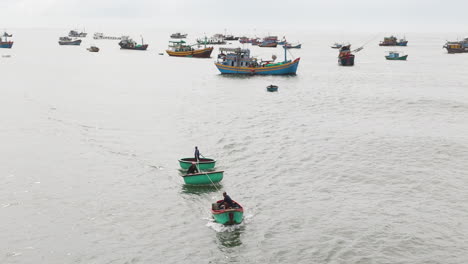 Local-Vietnam-fisherman-pulling-small-boats-through-waves,-aerial-view