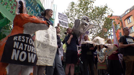 Protestors-with-banners,-placards-and-papier-mache-animals-gather-outside-the-offices-of-The-Department-for-Environment-Food-and-Rural-Affairs-on-the-Restore-Nature-Now-demonstration
