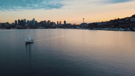 Aerial-tracking-shot-of-Sailing-Boat-on-Lake-Union-and-beautiful-Skyline-Silhouette-of-Seattle-City-in-background