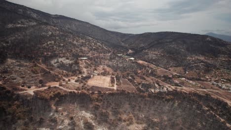 Forest-fire-aftermath-of-mountain-hillside-region-of-Parnitha-Greece,-aerial-high-angle-establishing-shot