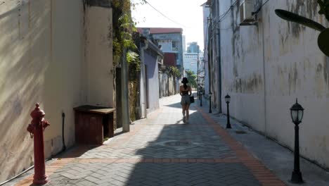 Young-female-walking-through-a-deserted-street-in-Penang,-Malaysia