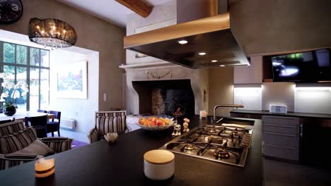 Slow-orbiting-shot-of-an-open-plan-kitchen-with-breakfast-bar-and-fireplace-in-a-castle