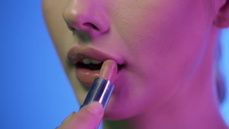 Close-up-slow-motion-shot-of-a-beautiful-young-woman-lips-as-she-presses-her-lips-together-to-spread-her-newly-applied-lipstick-after-getting-ready-for-night-evenly