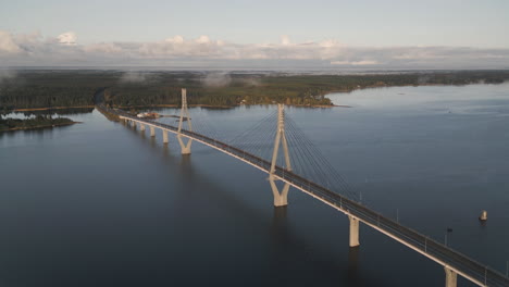 Drone-over-Replot-bridge-connecting-islands-in-Finland,-following-car-traffic-on-scenic-road-above-water,-autumn-day,-High-quality-4k-footage