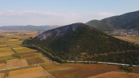 Aerial-approaching-burning-forest-over-agricultural-fields-in-Greece