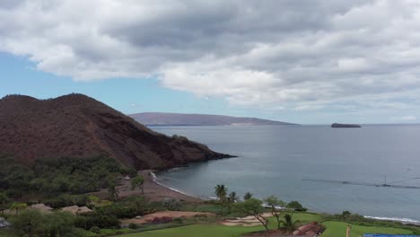 Aerial-wide-rising-shot-of-Maluaka-Beach-with-Molokini-Crater-and-Kaho'olawe-Island-in-the-distance-off-the-coast-of-Maui,-Hawai'i