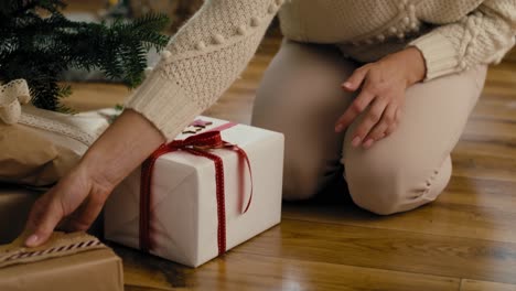 Mujer-Caucásica-Joven-Poniendo-Regalos-De-Navidad-Debajo-Del-árbol-De-Navidad.