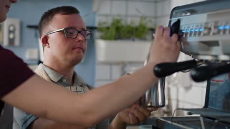 Caucasian-man-with-down-syndrome-as-a-waiter-helping-waitress-in-making-coffee.