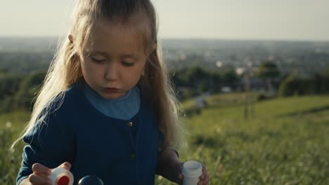 Cute-little-caucasian-girl-playing-with-bubbles-at-the-meadow.