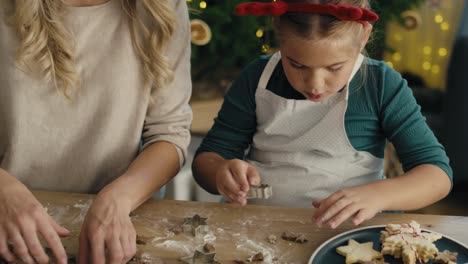 Tracking-video-of-caucasian-woman-with-daughter-making-cookies-in-Christmas-time-in-the-kitchen.