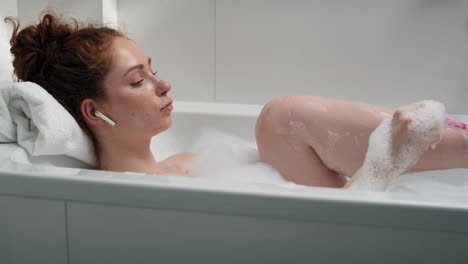 Caucasian-woman-taking-a-bath-and-shaving-legs.