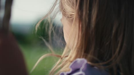 Close-up-of-girl's-hair-in-the-wind-swinging-in-summer-day.